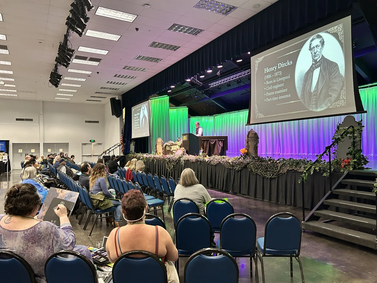 A history talk on the main stage under the green curtain glow